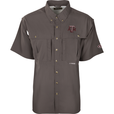 Texas A&M S/S Flyweight Wingshooter: A grey shirt with a logo, designed for warm-weather outdoor activities. Made of ultra-lightweight polyester fabric that dries quickly and wicks moisture away. Features include UPF 50+ sun protection, vented back, chest pocket, and zipper pocket.