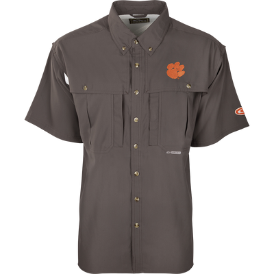 Clemson S/S Flyweight Wingshooter: A grey shirt with an orange logo and tiger paw patch. Made of ultra-lightweight polyester for quick-drying and breathability. Features include UPF 50+ sun protection, vented back design, Magnattach™ chest pocket, and vertical zipper pocket. Ideal for warm-weather outdoor activities.