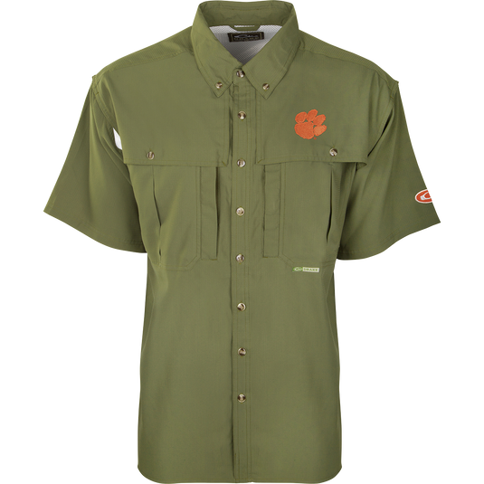 Clemson S/S Flyweight Wingshooter: A green shirt with a logo, designed for warm-weather outdoor activities. Made of ultra-lightweight polyester, it dries quickly and wicks moisture away. Features include UPF 50+ sun protection, vented back, chest pockets, and a vertical zipper pocket.