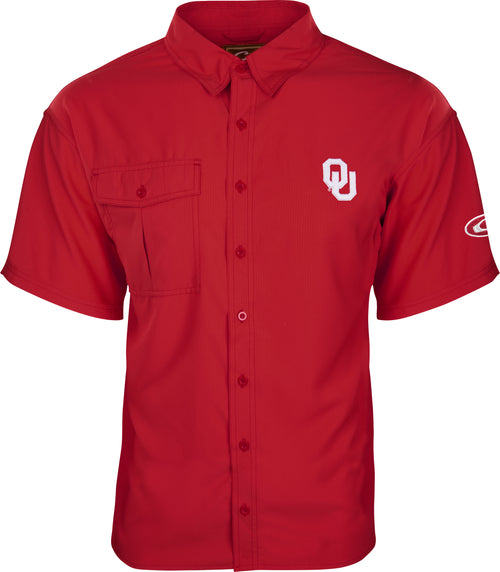 A close-up of the Oklahoma S/S Flyweight Shirt, a red shirt with a logo. Made of 100% polyester Flyweight fabric, it's quick-drying, breathable, and offers UPF 50+ sun protection. Features include a vented mesh back and a large chest pocket. Perfect for warm-weather outdoor activities.