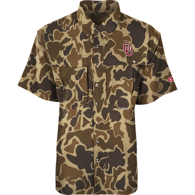 A close-up of the Oklahoma S/S Flyweight Wingshooter shirt with a logo. Lightweight, breathable, and quick-drying polyester fabric. Features include vented back design, UPF 50+ sun protection, chest pockets, and a zippered pocket. Ideal for warm-weather outdoor activities.