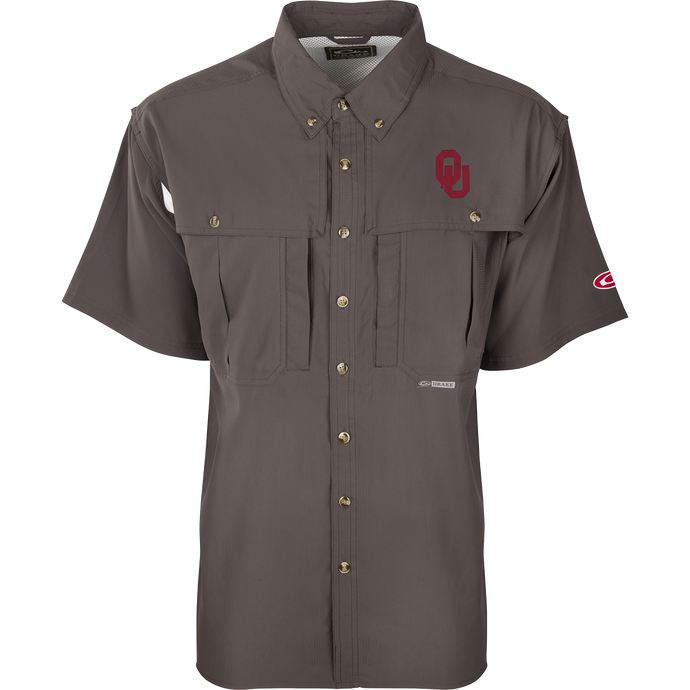A close-up of the Oklahoma S/S Flyweight Wingshooter shirt, featuring a logo, vented back design, and multiple pockets. Lightweight, breathable, quick-drying, and moisture-wicking, this shirt is perfect for warm-weather outdoor activities. Made of 100% polyester with UPF 50+ sun protection.
